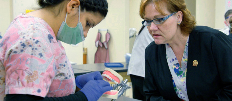 Dental assistant demonstrating cleaning technique