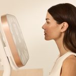 A woman receiving a facial scan with the Aura 3D Imaging System at a medical aesthetics clinic.